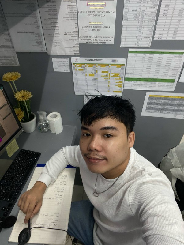 A person working at a computer with a headset